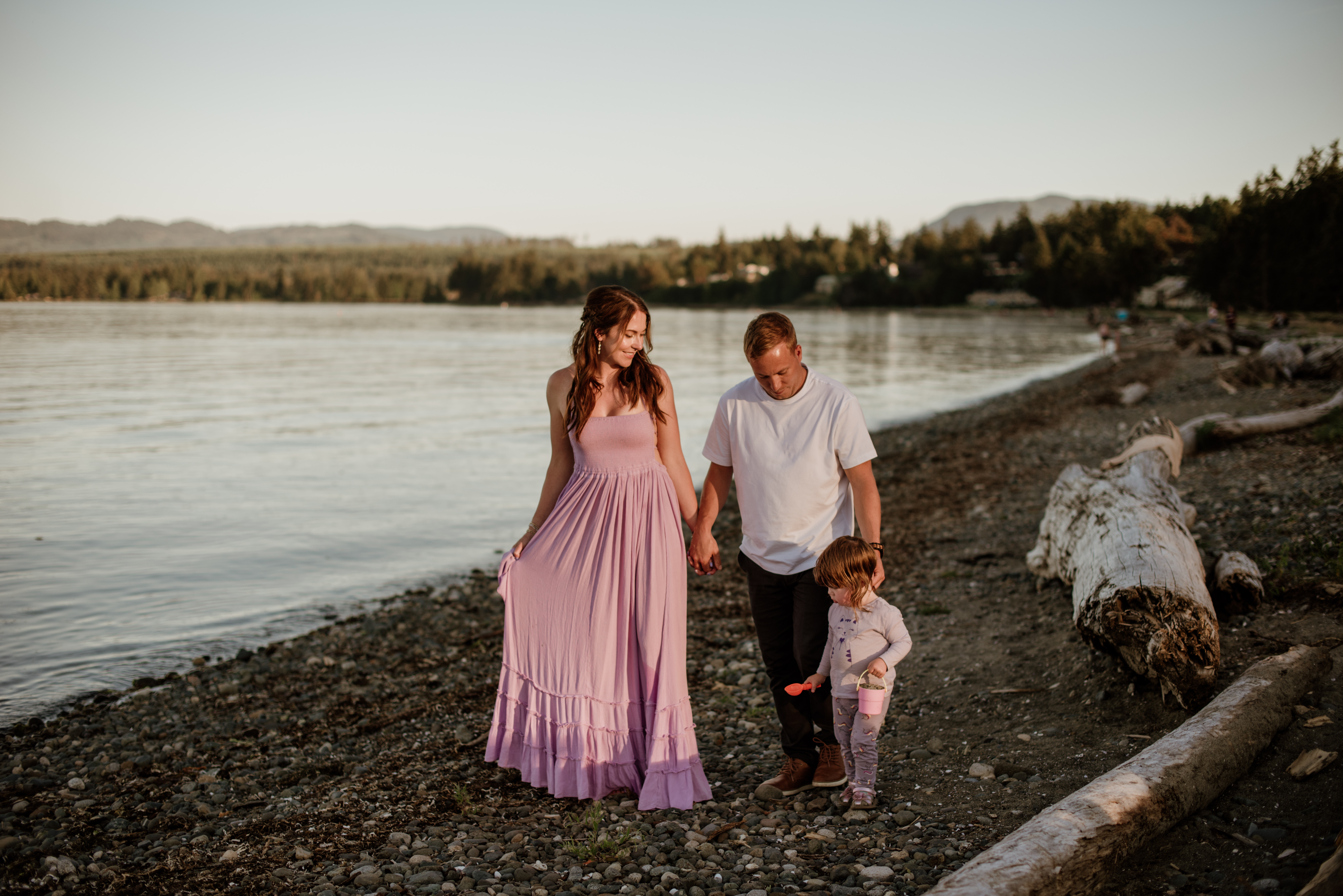Talana Tisdale walking on a pebble beach at golden hour with her family